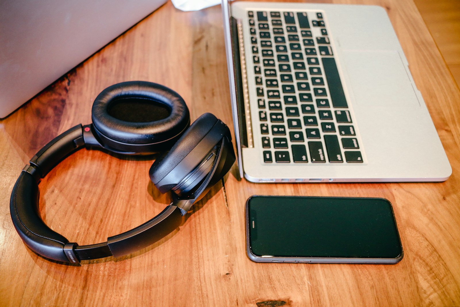 Ordinateur portable et casque posés sur une table en bois