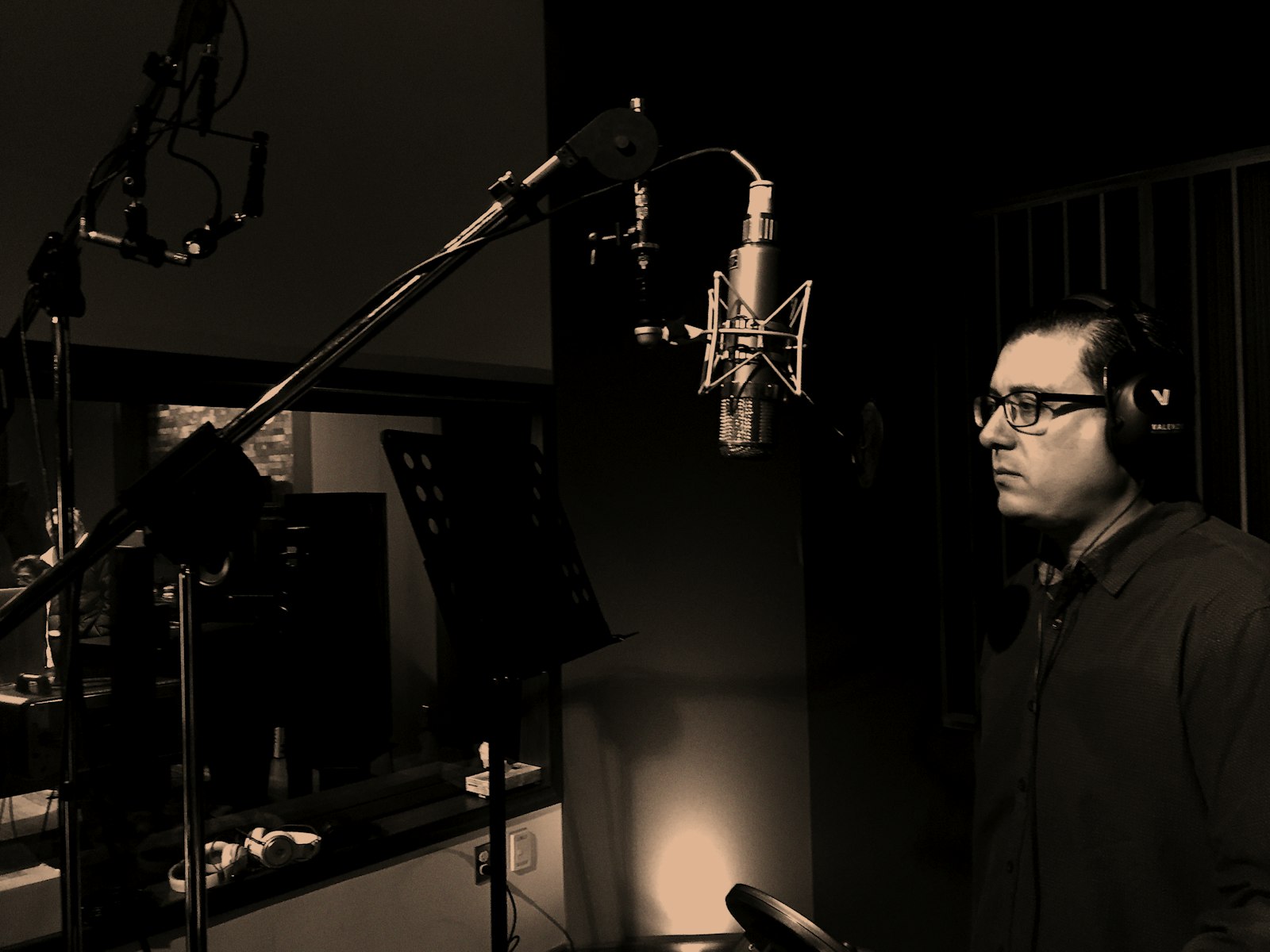 Homme debout devant un microphone statique dans un studio