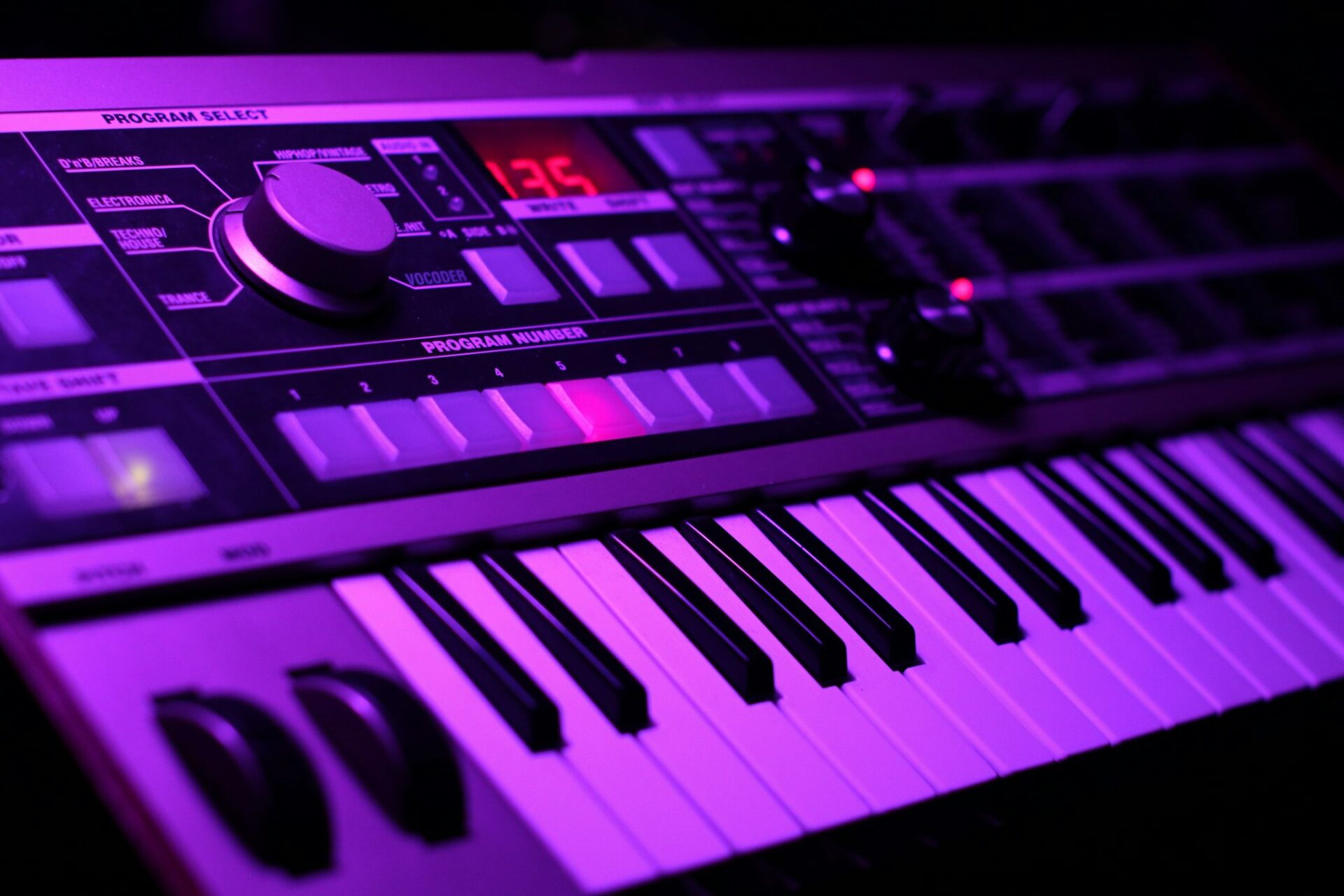 Clavier de synthétiseur illuminé de violet en gros plan