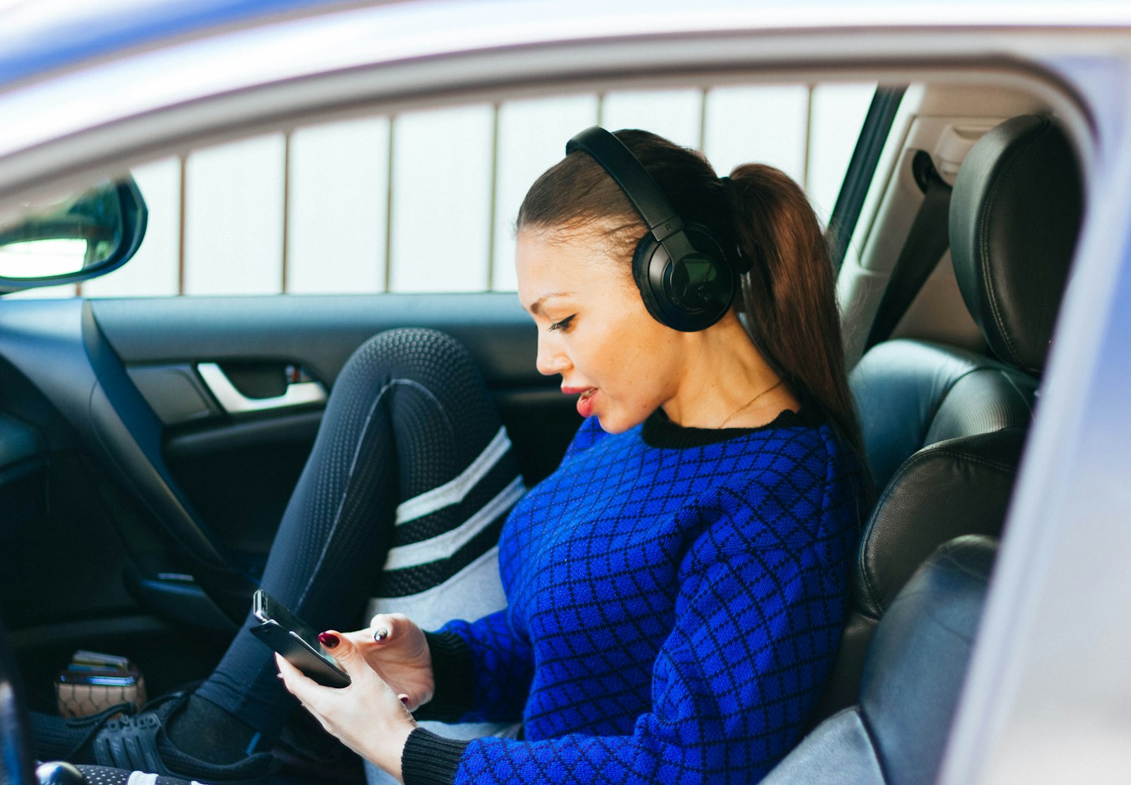 Femme portant un casque audio à l'intérieur d'un véhicule