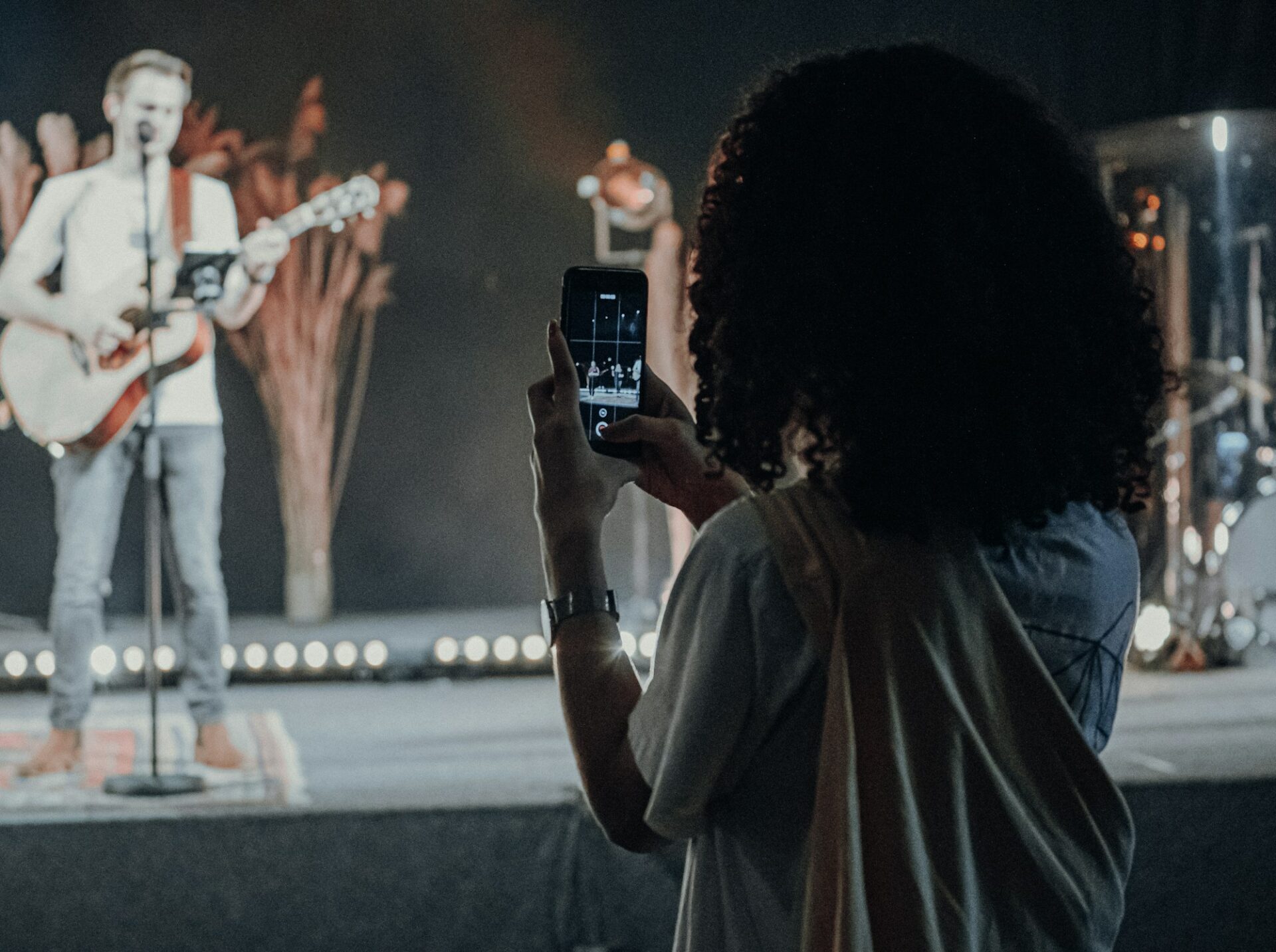 Personne filmant un chanteur avec son smartphone
