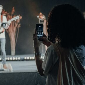 Personne filmant un chanteur avec son smartphone