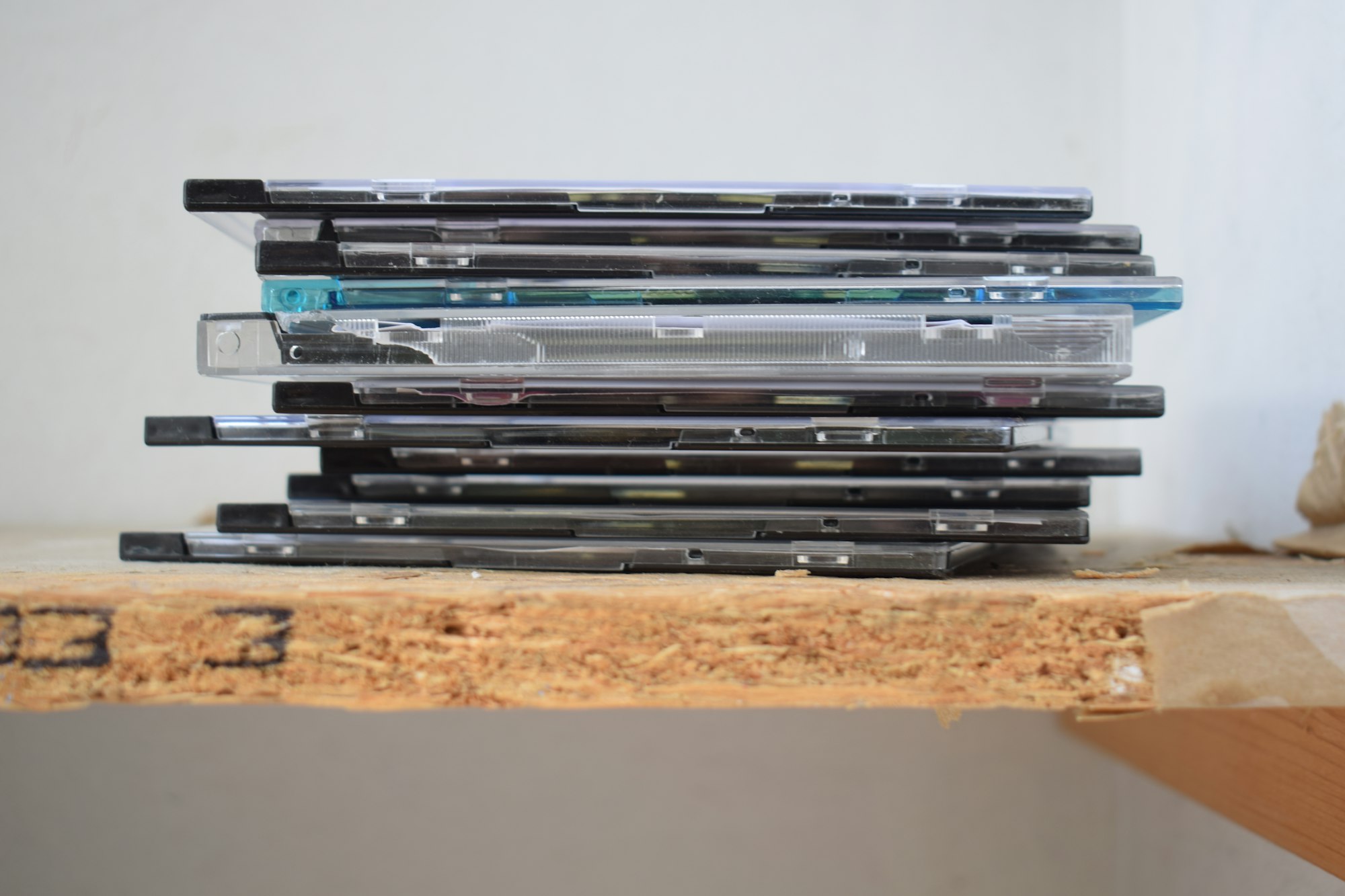 Pile de boîtiers de disques compacts posée sur une étagère en bois