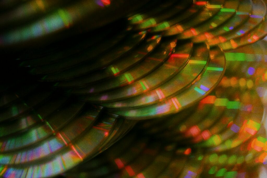 Pile de disques compacts renvoyant des reflets de lumière colorés