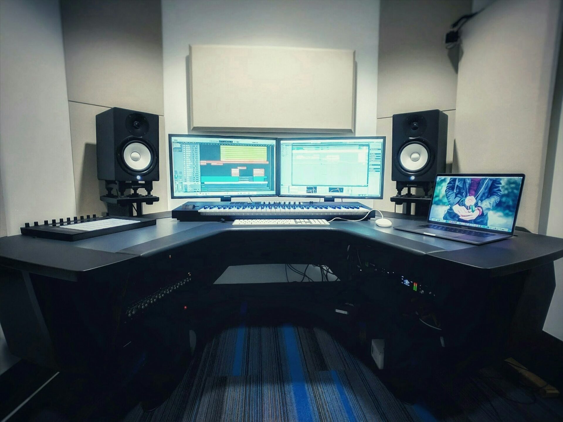 Poste de travail de studio avec deux écrans, un clavier et des enceintes de monitoring