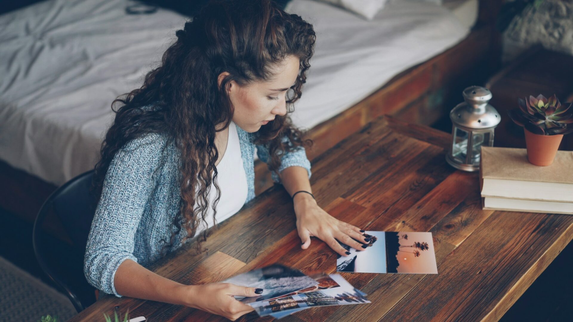 Photographe triant des tirages photo étalés sur une table en bois
