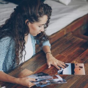 Photographe triant des tirages photo étalés sur une table en bois