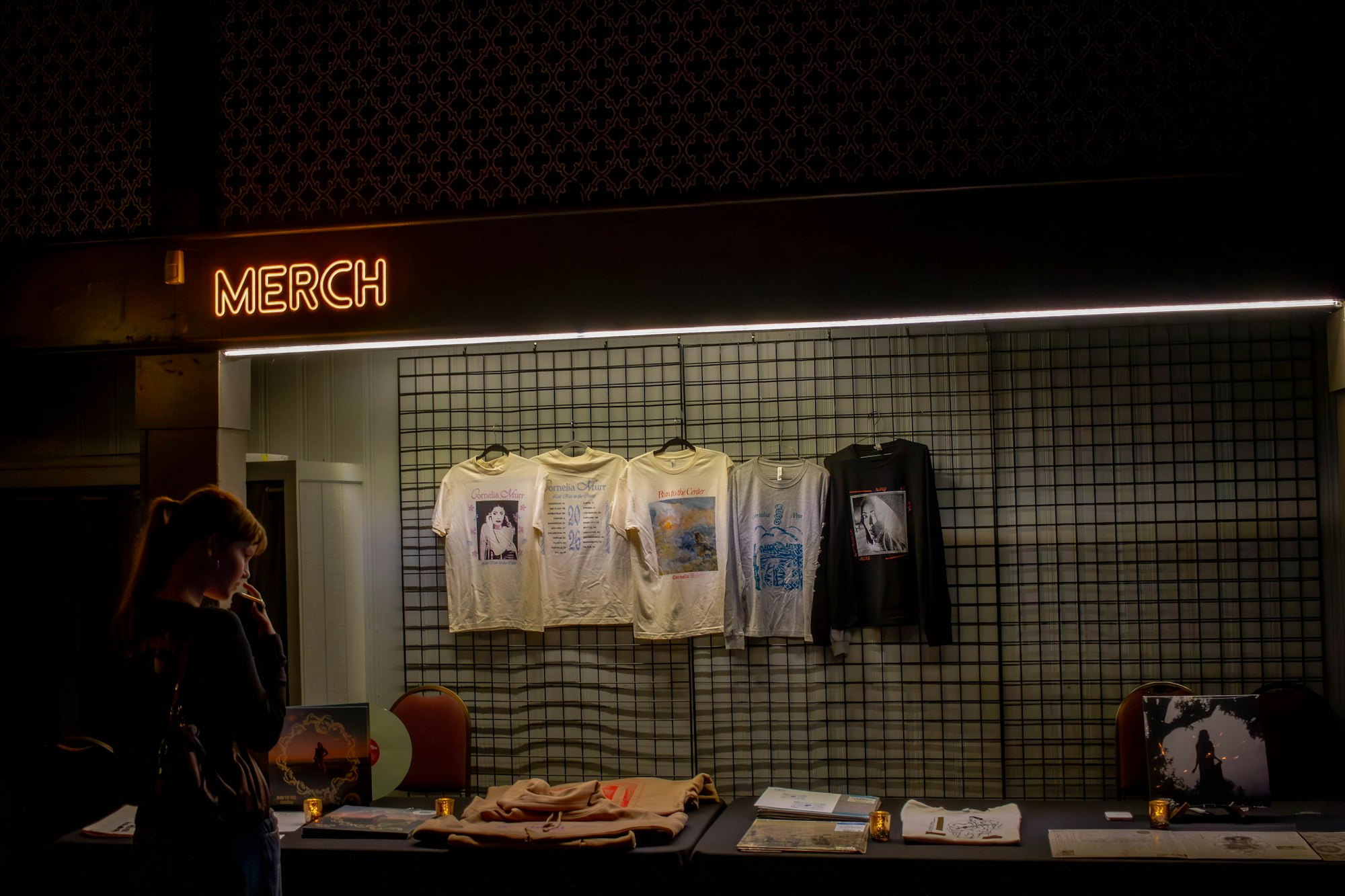 Personne regardant les articles d’un stand de merchandising faiblement éclairé