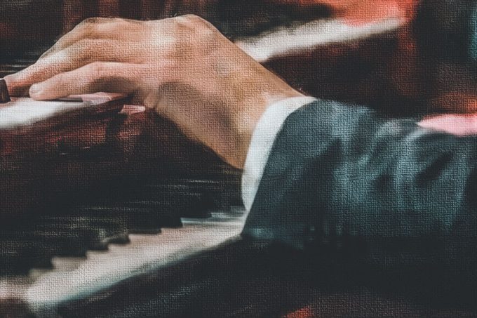 The hand on the keys of the piano.